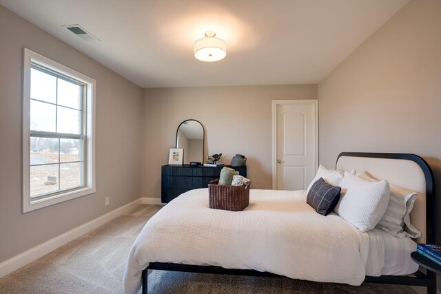 bedroom featuring light carpet, visible vents, and baseboards