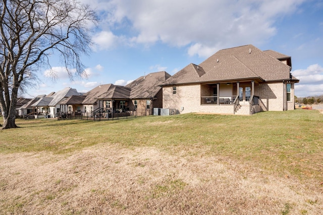 back of house with a patio area, a lawn, brick siding, and a shingled roof