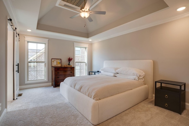 bedroom featuring multiple windows, light colored carpet, a tray ceiling, and a barn door