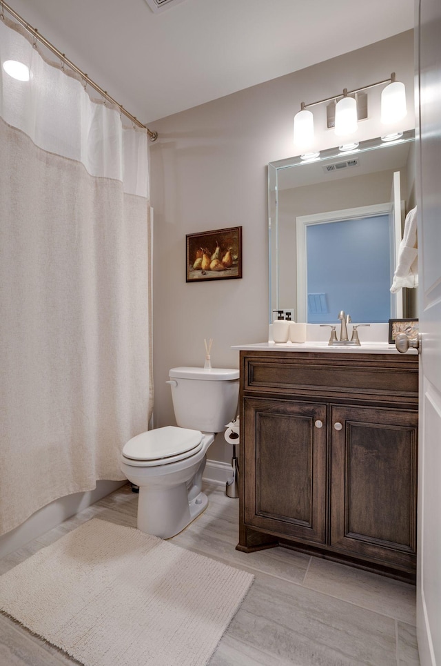 bathroom featuring visible vents, toilet, a shower with shower curtain, wood finished floors, and vanity