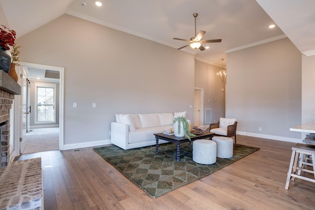 living area featuring wood finished floors, crown molding, a fireplace, and high vaulted ceiling