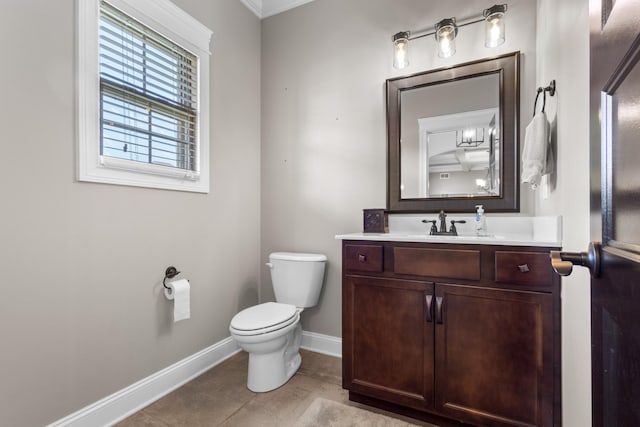 half bathroom featuring tile patterned flooring, toilet, vanity, and baseboards