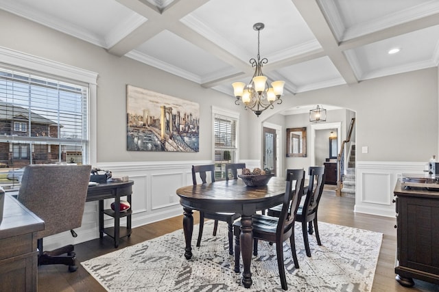 dining area with beamed ceiling, a notable chandelier, coffered ceiling, dark wood finished floors, and arched walkways