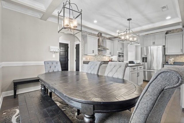 dining space featuring dark wood finished floors, crown molding, visible vents, and a chandelier