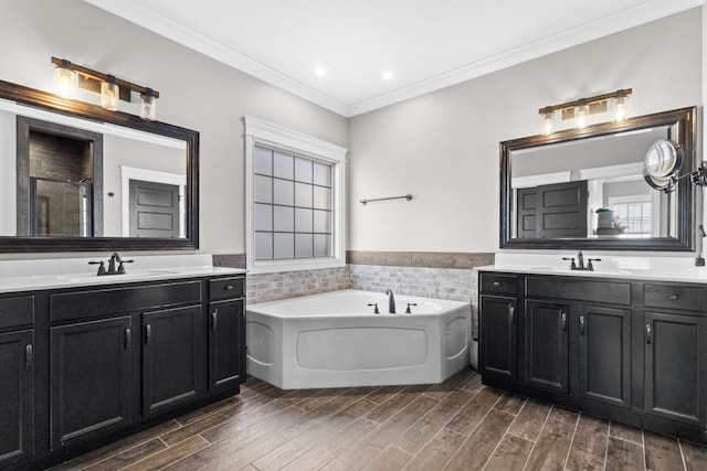 bathroom with wood tiled floor, a bath, crown molding, and a sink