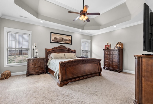 carpeted bedroom featuring a tray ceiling, baseboards, visible vents, and crown molding