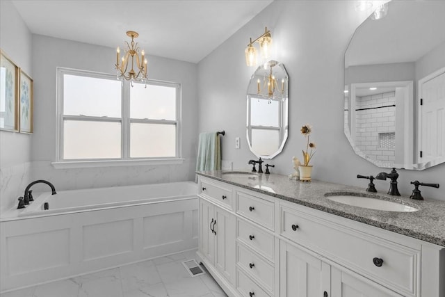 bathroom featuring a garden tub, double vanity, marble finish floor, and a sink