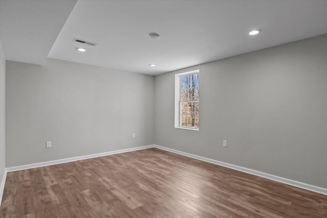 unfurnished room with recessed lighting, visible vents, baseboards, and wood finished floors