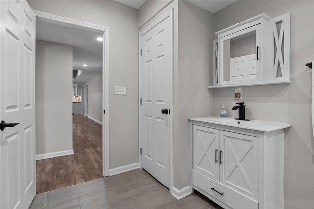 bathroom featuring vanity, baseboards, and wood finished floors