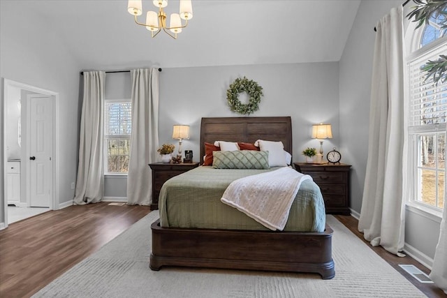 bedroom featuring visible vents, lofted ceiling, wood finished floors, an inviting chandelier, and baseboards