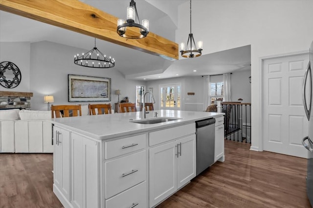 kitchen with dark wood-type flooring, a sink, lofted ceiling with beams, stainless steel dishwasher, and open floor plan