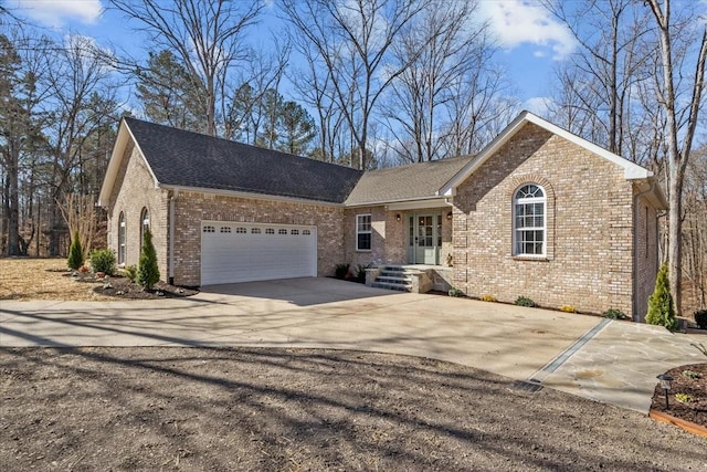 ranch-style house with brick siding, concrete driveway, a garage, and roof with shingles