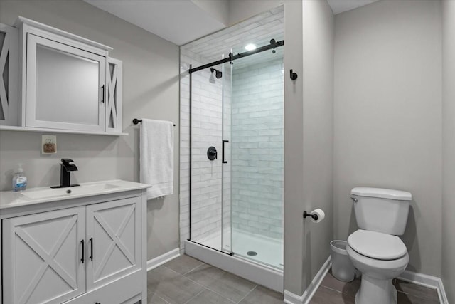 bathroom with tile patterned flooring, baseboards, toilet, a stall shower, and vanity