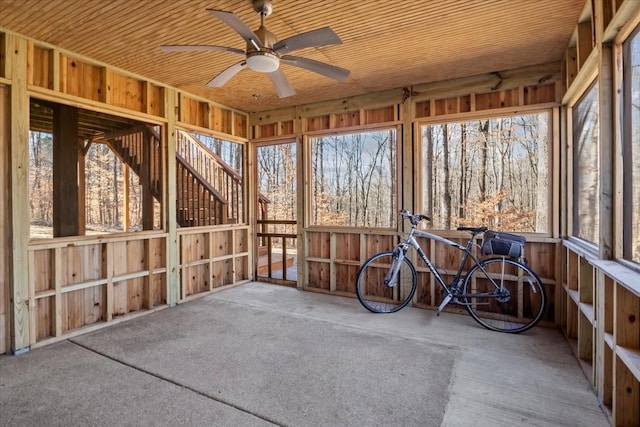 unfurnished sunroom with wooden ceiling and a ceiling fan