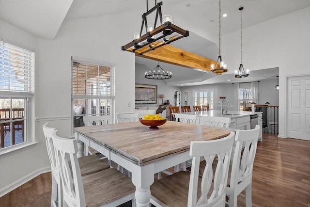 dining space with a chandelier, lofted ceiling, and dark wood finished floors