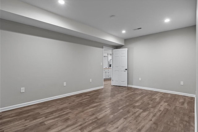 below grade area featuring dark wood finished floors, recessed lighting, baseboards, and visible vents