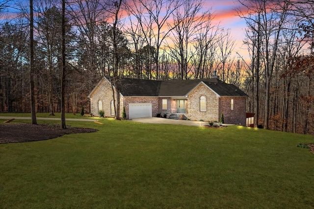 view of front facade with a garage, driveway, a chimney, and a front yard