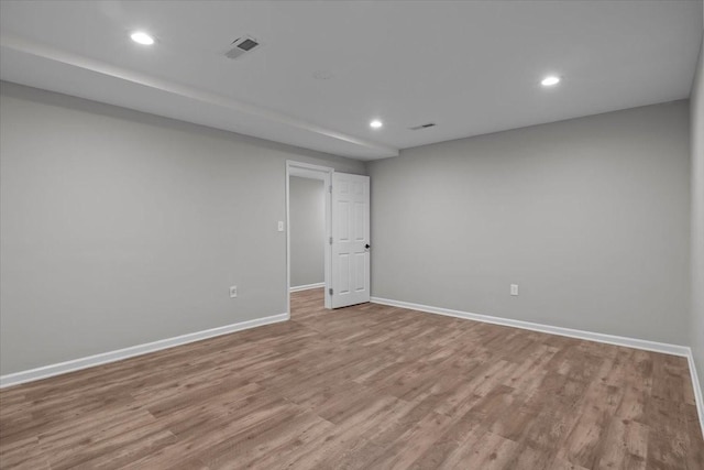 spare room with recessed lighting, wood finished floors, and baseboards