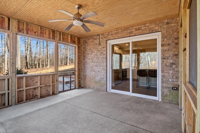 unfurnished sunroom featuring wood ceiling and ceiling fan