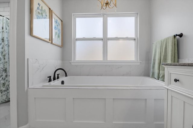 bathroom with vanity and a bath