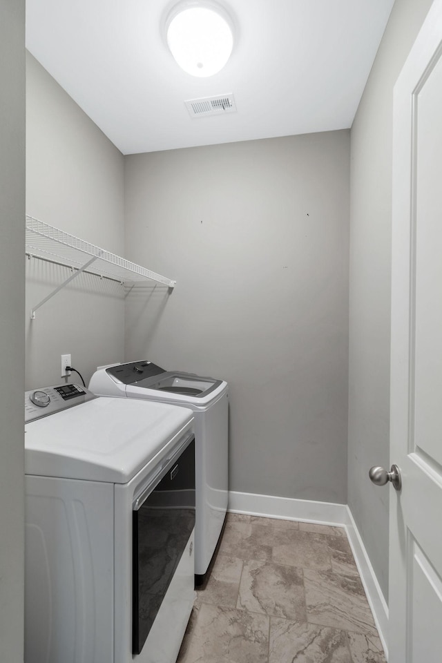 laundry room with visible vents, baseboards, laundry area, marble finish floor, and washer and clothes dryer