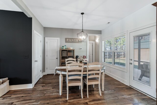 dining space featuring visible vents, baseboards, dark wood-type flooring, and a chandelier