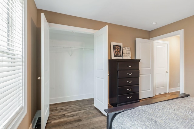 bedroom with a closet, baseboards, and dark wood-style flooring