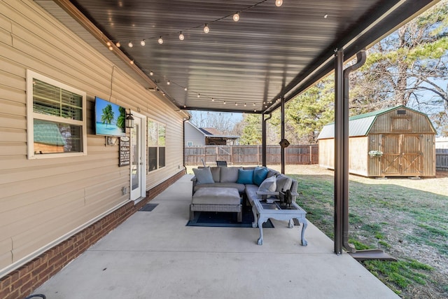 view of patio / terrace featuring an outdoor structure, a storage unit, a fenced backyard, and an outdoor hangout area