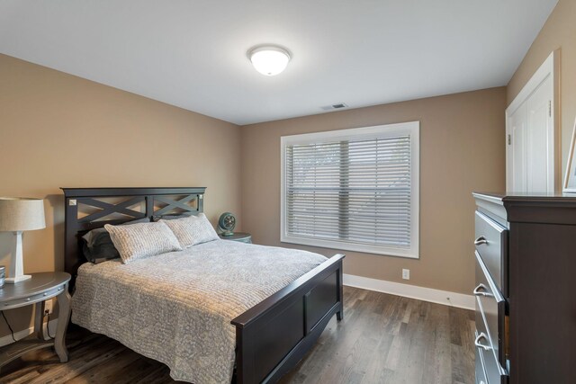 bedroom with visible vents, baseboards, and dark wood-style flooring