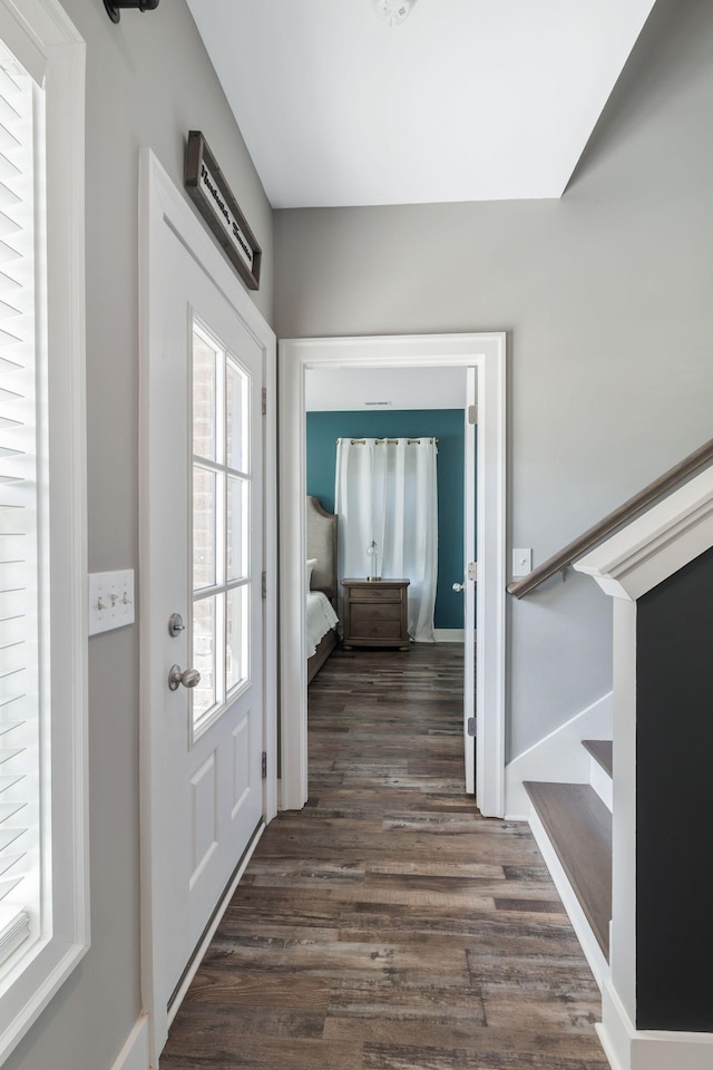 doorway with dark wood finished floors and baseboards