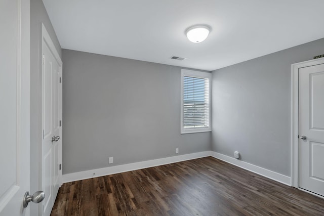 unfurnished bedroom with visible vents, baseboards, and dark wood-type flooring