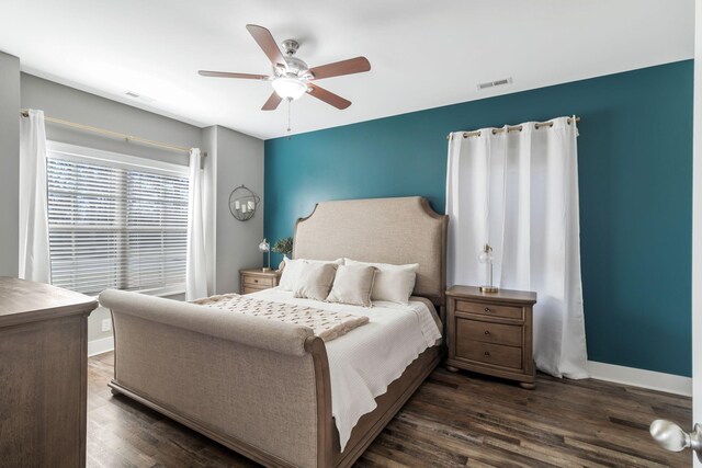 bedroom featuring visible vents, ceiling fan, dark wood-type flooring, and baseboards