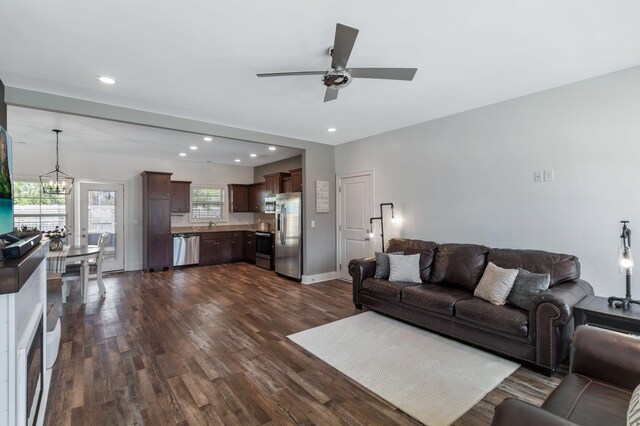 living room with recessed lighting, baseboards, dark wood finished floors, and ceiling fan with notable chandelier