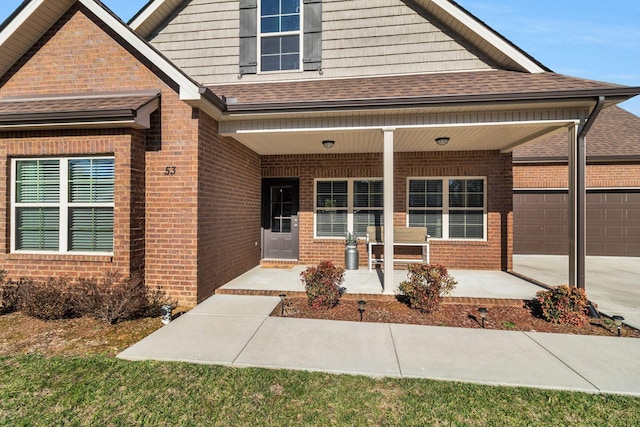 view of front of home featuring brick siding, roof with shingles, covered porch, and an attached garage