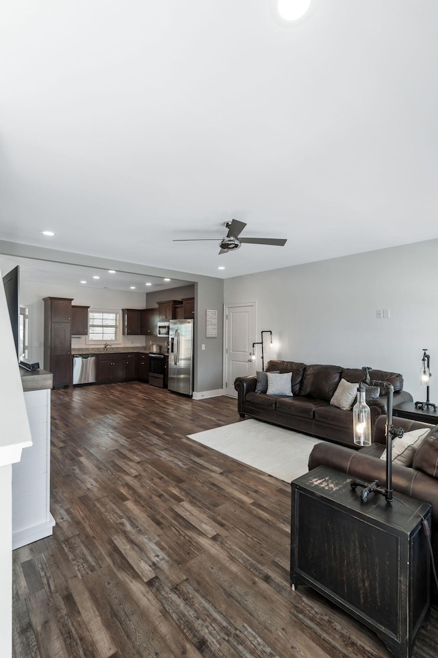 living area with recessed lighting, baseboards, dark wood-type flooring, and a ceiling fan