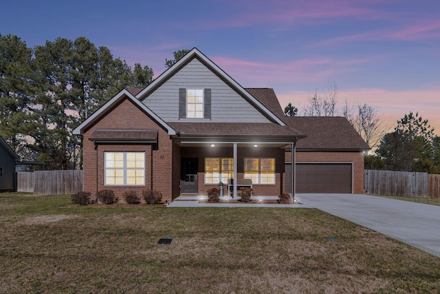 view of front of home featuring brick siding, fence, and a lawn