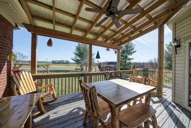 deck with outdoor dining space and a rural view