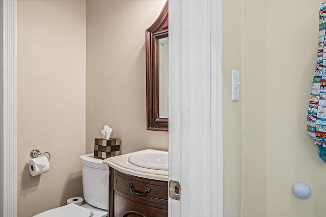 half bathroom with vanity and toilet