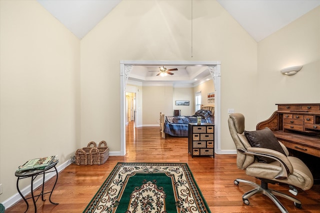 office space with ceiling fan, baseboards, high vaulted ceiling, and wood finished floors