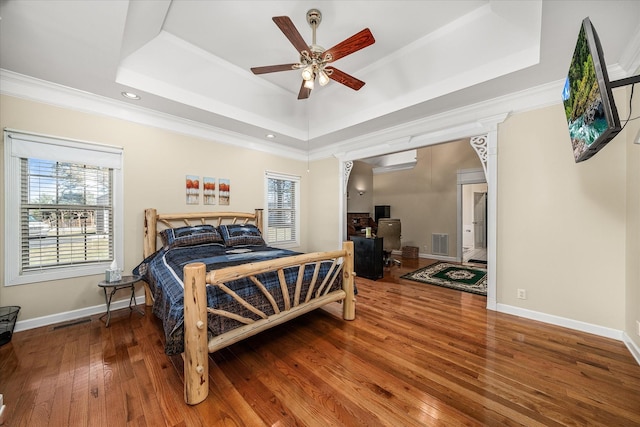 bedroom with visible vents, multiple windows, and a raised ceiling