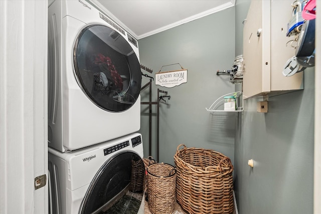 laundry room featuring laundry area, stacked washer and clothes dryer, and crown molding