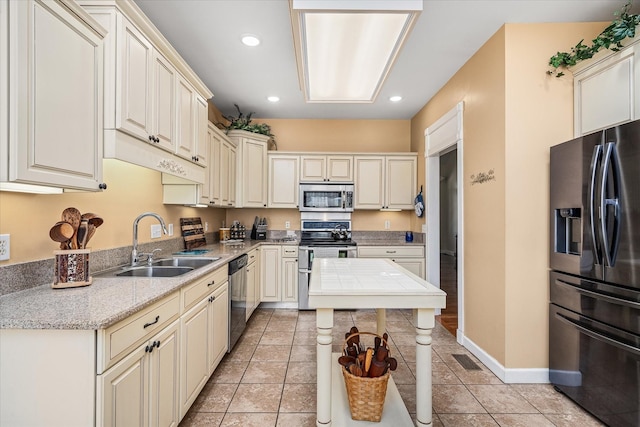 kitchen with light tile patterned floors, recessed lighting, appliances with stainless steel finishes, and a sink