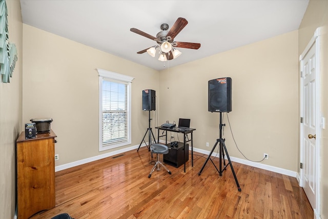 office with a ceiling fan, baseboards, and wood finished floors