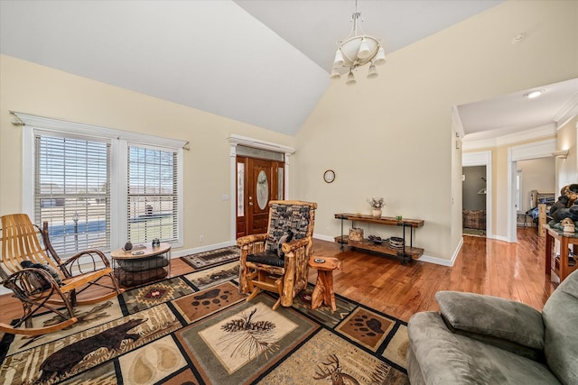 living room featuring a chandelier, baseboards, high vaulted ceiling, and wood finished floors