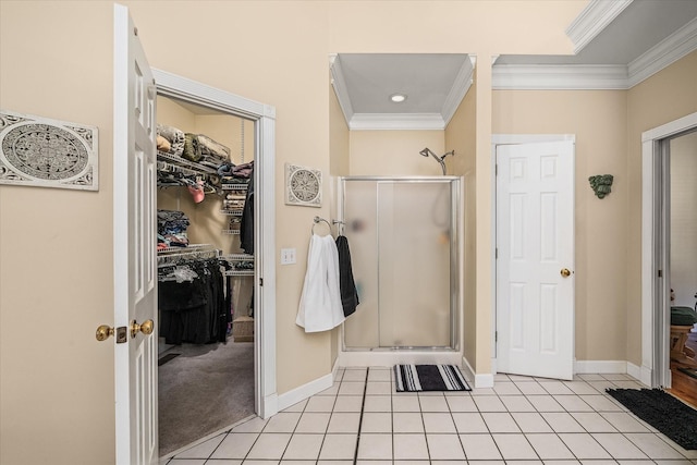 full bath with tile patterned flooring, a spacious closet, baseboards, ornamental molding, and a stall shower