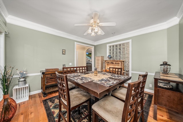 dining area with baseboards, light wood-style floors, ceiling fan, and crown molding