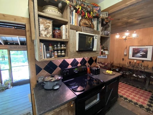 bar with black electric range, decorative backsplash, white microwave, and wooden walls