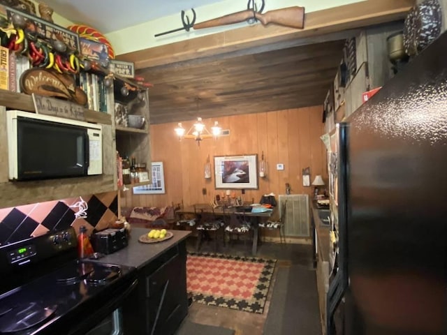 kitchen featuring black / electric stove and wood walls