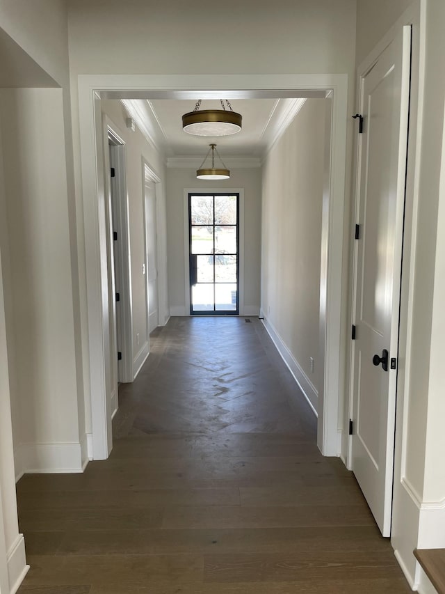 hall featuring baseboards, dark wood-style flooring, and ornamental molding