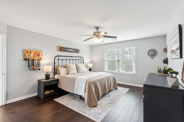 bedroom with dark wood-style floors, visible vents, a ceiling fan, and baseboards